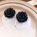 Primo piano di orecchini a rosa in resina nera con dischi in conchiglia su un piatto. - Perno in Argento - Nero - Trasparente