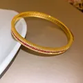 Detail view of retro gold-toned bangle with red and white pavé-set zircons - Gold-Red