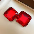 Detailed macro view of square faceted red crystal stud earrings in silver claw setting - Red