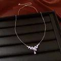 Detail shot of elegant silver necklace with pearls and teardrop zircon on black tray - White