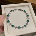 Close-up of elegant green zircon flower bracelet inside a light beige jewelry gift box - Flower Style (HB5804) / Silver-Lake Blue