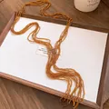 Detail shot of a vintage ethnic style multi-strand beaded necklace with amber crystal tassels - Brown