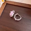 Detailed view of silver hoop earrings featuring delicate pink enamel flowers on wood - Ear Buckle / Pink
