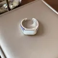 Primer plano de un anillo abierto geométrico plateado con una elegante resina blanca ovalada - Estilo 4 (HR3086)