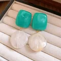 Gros plan de boucles d'oreilles vintage élégantes en résine marbrée bleu-vert et blanc crème - Style d'Épissage Carré et Rond / Vert/Blanc