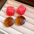 Gros plan de boucles d'oreilles rétro en résine avec carrés rouges et éléments ronds ambrés - Style d'Épissage Carré et Rond / Rouge/Café