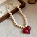 Dettaglio ravvicinato di una collana vintage con cuore e perle di acrilico - Caffè Rosso