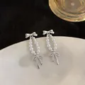 Dettaglio di orecchini a perla in stile francese con eleganti fiocchi argentati - Stile Fiocco con Perno in Argento (HE32565) / Argento