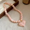 Primo piano di una collana di perle acriliche marmorizzate rosa con cuore - Rosa