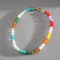 Close-up of vibrant multi-color beads and a gold-toned spring ring clasp on grey surface - Necklace-Multicolor Type 1