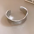Primer plano de un brazalete plateado minimalista con una textura arrugada única - Bangle / Plateado
