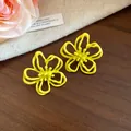 Primer plano de pendientes de flores huecas en amarillo brillante con acabado de aceite - Estilo Floral Hueco (HE32264) / Amarillo