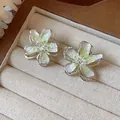 Close-up of elegant flower stud earrings featuring green gradient enamel and subtle glitter - Green