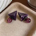 Vista macro di orecchini geometrici in resina viola con pendenti marmorizzati - Viola