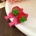 Gros plan de barrettes à cheveux fraises en résine rose fuchsia sur une assiette blanche - Fraise