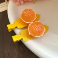 Détail de barrettes à cheveux mandarine en résine avec base bec de canard jaune. - Orange