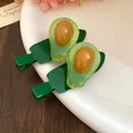 Vue détaillée de barrettes à cheveux en résine en forme d'avocat sur une assiette blanche. - Papaye