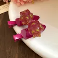 Vue détaillée des pinces à cheveux fruit du dragon en résine sur une assiette blanche. - Fruit