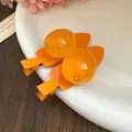 Gros plan de barrettes à cheveux en résine en forme de fruit avec clips orange - Mangue