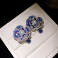 Close-up macro of luxury floral earrings featuring blue crystals and white center pearls - Camellia Shape / Silver Earring Post - Silver - Blue