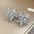 Vista dettagliata di orecchini a lobo a fiore in argento con elegante texture metallica. - Argento