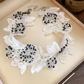 Close-up of a white lace choker necklace with black and white beaded flower patterns. - White Black Wide Necklace