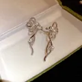 Dettaglio di orecchini a clip in argento con zirconi scintillanti e perle eleganti - Stile Fiocco / Argento