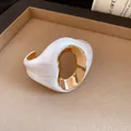 Macro view of a vintage white marble resin and gold-plated irregular cuff bracelet. - White