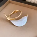 Detailed view of a vintage gold-toned bracelet with a white pleated petal design. - Gold-White