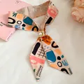 Close-up detail of abstract printed long scarf with pearl buckle accessory - Coffee Print