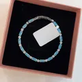 Detail view of light luxury bracelet with blue rectangular zircons in a box - Bracelet / Transparent Blue