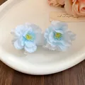 Close-up of elegant light blue fabric flower hair clips with delicate petals - Single Piece / Blue