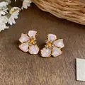 Macro view of elegant French luxury pearl flower stud earrings with crystal center - Silver Post (HE33386) / Purple