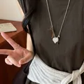 Close-up of minimalist silver 3D beaded heart necklace on dark brown dress - Style 1 (HN12547-1) / Silver