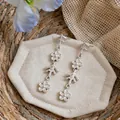 Primo piano di orecchini vintage con nappe a fiori e dettagli in diamanti incastonati. - Stile nappa floreale / Argento
