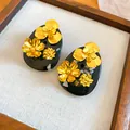 Close-up of vintage Chinese style resin earrings with intricate gold flower details. - Flower Style (HE34308) / Gold-Black