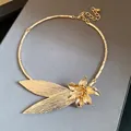 Detailed macro view of a vintage gold metallic flower and leaf choker style necklace - Gold