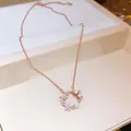 Close-up of rose gold necklace featuring zircon butterfly and shell flower pendant - Rose Gold