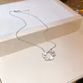 Detailed view of silver necklace with zircon flower and mother of pearl butterfly pendant. - Silver