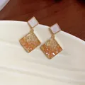 Nahaufnahme von 14k vergoldeten Rautenohrringen mit bernsteinfarbenem Glasdetail. - Geometrischer Rhombus-Stil (HE31796) / Gold/Braun