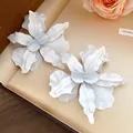Macro view of white spray-painted flower earrings with a matte finish on jewelry box - White