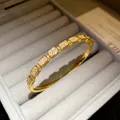 Detail shot of 18K gold plated bangle with sparkling cubic zirconia in jewelry box. - Style 2 / Gold