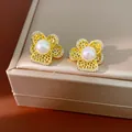 Detailansicht goldfarbene Ohrringe in Blumenform mit zentralen Perlen und Zirkonia-Akzenten. - 925 Silber Stift Stil / Gold