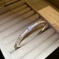 Detailed close-up view of an elegant 18K gold plated zircon pavé bangle in a jewelry box - Silver