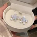 Close-up of elegant white flower stud earrings with crystal centers in a gift box - Flower Stud Earrings / Pink