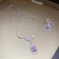 Exquisite jewelry set with pear-cut pink gemstone pendant and matching halo earrings. - Necklace Earrings Ensemble (Silver) / Pink
