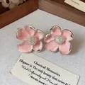 Vue détaillée de boucles d'oreilles fleurs en émail rose élégantes avec finition argentée - Rose