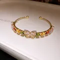 Elegant gold open bracelet with colorful zircon waterdrop stones and a crystal butterfly - Gold-Multicolor