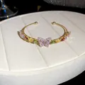 Exquisite gold open cuff bracelet with a purple zircon butterfly charm and multi-colored stones. - Gold - Multicolored Purple