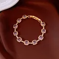 Vue détaillée des zircons violets carrés sur un élégant bracelet de luxe doré - Bracelet Plaqué Or Véritable / Violet Or